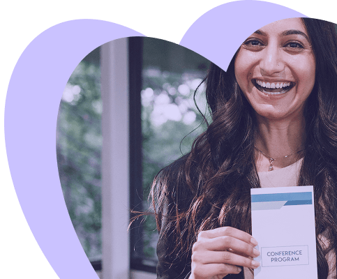 Smiling event attendee holding a conference program